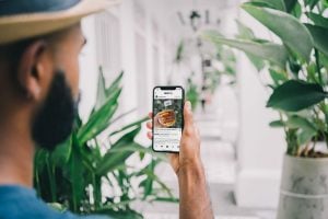 man holding phone looking at instagram post